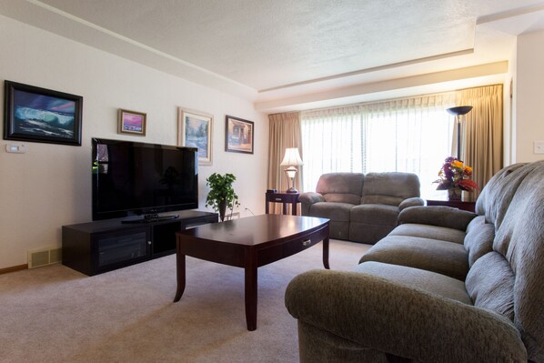 Living room with 65" HDTV with blu ray player and Netflix!