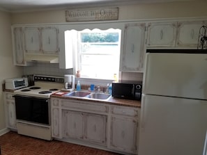 A full kitchen with a 4 seat pub table