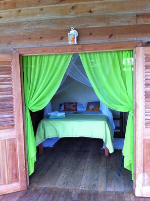 The Green room's queen size bed + nets over looking Castara bay