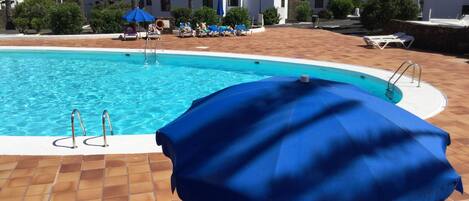 Heated pool with sunlougers and umbrellas