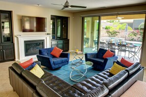 Living room with 60" HD TV and double doors out to the patio