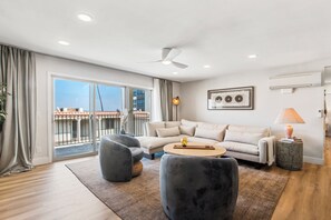Newly furnished living area with ample seating, large flat screen television, air conditioning, and access to patio just off of the beautiful, open kitchen.