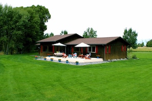 Back deck surrounded by lush expanse of lawn