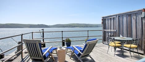 Large private bayfront deck with hot tub and lounge chairs