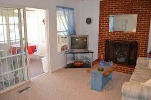 Living room with pull out couch leading to the sunroom.