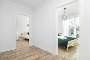 Entrance from a bright hallway to two bedrooms.