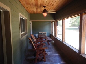 Screened porch with cedar gliders and picnic table for outdoor meals