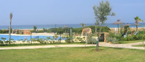 Vista del jardín y piscina, al fondo el mar