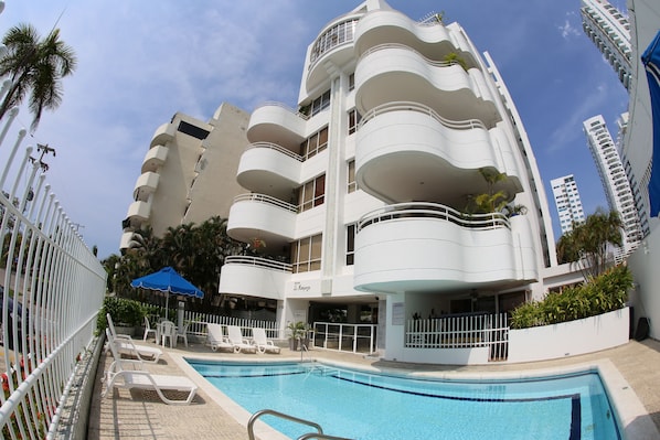 Building and pool that is directly accessed from condo patio   