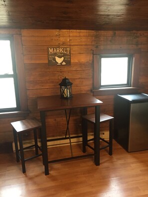 Cute kitchenette with small stainless steel fridge.