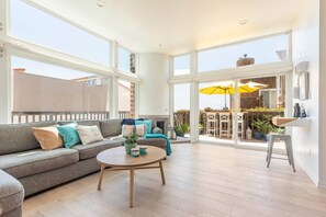 Living room, small desk, oversized sofa, fireplace, amazing sea view