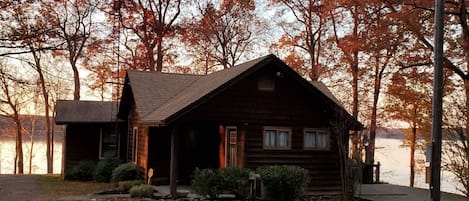 View of Lake House, from the paved driveway, as the sun has set for the day