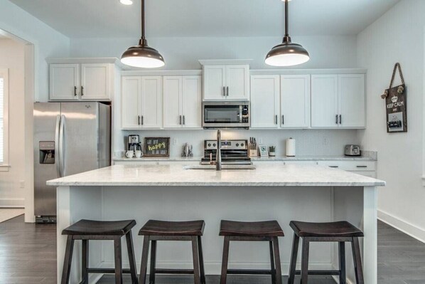 Kitchen fully stocked with all cooking essentials, oven, dishwasher, microwave, stove and drop coffee maker