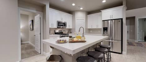 Photo of whole room stocked with all the comforts of home. Featuring top of line appliances and cooking utensils.