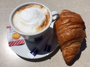 Das klassische, kleine Frühstück in Frankreich, ein Croissant mit einem Café.