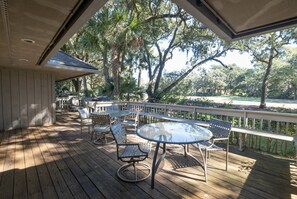 Lovely, large back porch with seating and chaise lounges. Tables seat 10