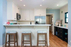 A breakfast bar separates the living room and kitchen