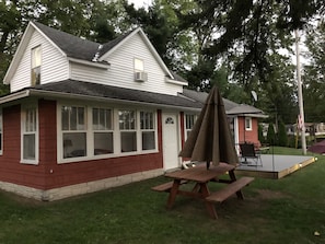 Entry door connects to a small screened  windowed porch with couch and dart game