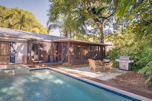 The poolside seating area includes a BBQ grill and garden seating area.