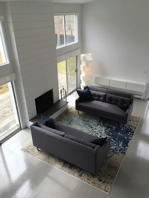 Two story living room is filled with light and seating!