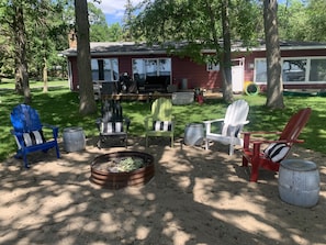 Fire pit area with 5 Adirondack chairs. 