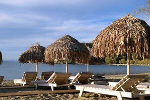 Sunbeds and umbrellas on the beach of Otzia