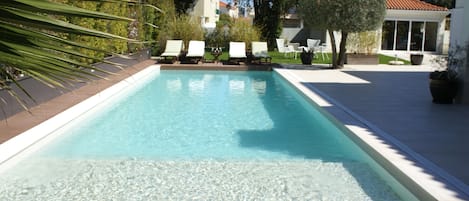 Vue piscine (chauffée), plage de bronzage et jardin