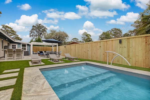 Private heated pool with outdoor grill/kitchen, dining table and shaded seating