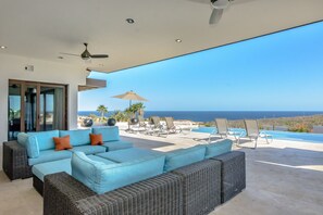 Fan cooled and shaded outdoor living room overlooking the pool and water views.