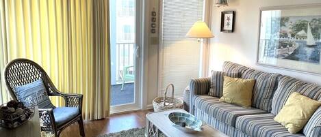 Living room with flat screen smart TV and private screened balcony