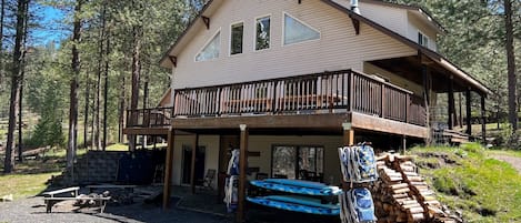 Waterfront side of house with provided beach chairs, paddle board and fire pit