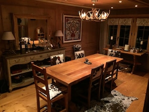 Stubli style Dining room for 8 with hide covered chairs and antler chandelier