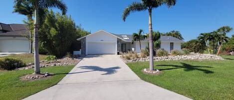 Front of house and garage door with the main entrance to the right.