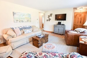 living room with couch, lazy boy and large TV