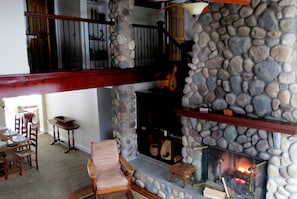 The Living Room has a cathedral ceiling with riverstone wood burning fireplace