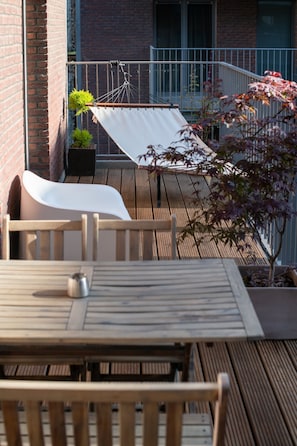 Large covered terrace with patio table for 4, a chair and a hammock