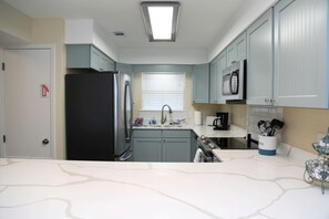 Ample space for prepping home-cooked meals on the newly installed quartz countertop.