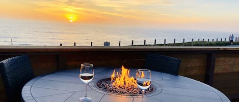 Fire table and chairs on the deck with sunset view