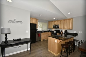 Large kitchen with granite counter tops and bar seating