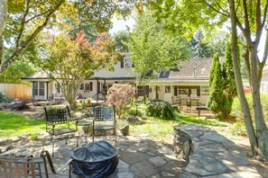 Patio in back of the yard with a fireplace overlooking the home and grounds.