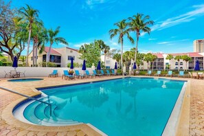Valencia heated pool and jacuzzi. Pool deck with chaise lounges and umbrellas