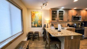 The lovely bar/dining area features seats for two - with additional seating for more thanks to the bench and two additional stools nearby.