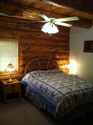 Cozy log bedroom on main with queen bed, french doors and shared bathroom. 