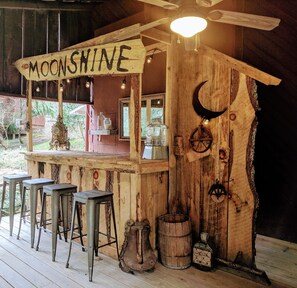 One-of-a-kind moonshine bar on the front porch with outside games underneath!