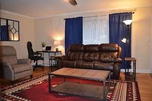 Great room with desk and electric recliner sofa, and reclining arm chair.