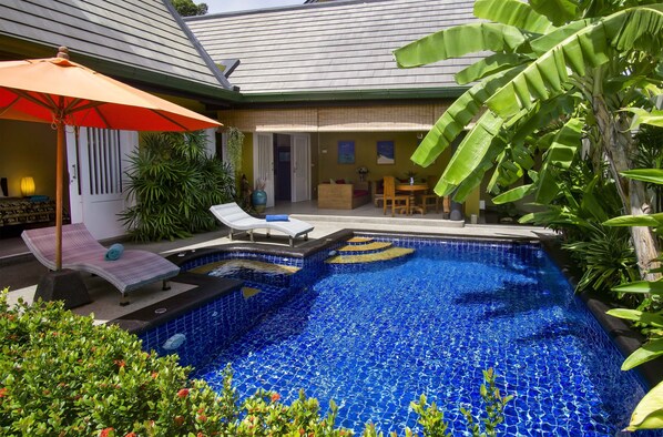 Vibrant saltwater pool area with shaded patio for outdoor dining & relaxing