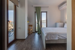 Room with flat screen TV , air conditioning and small refrigerator.