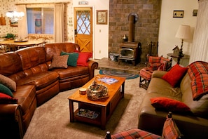 Living room with wood burning stove and leather couches (hide-a-bed on right)