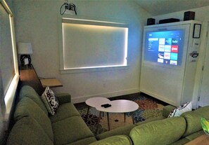 The living room has a projector with access to Netflix, Hulu, and Disney+