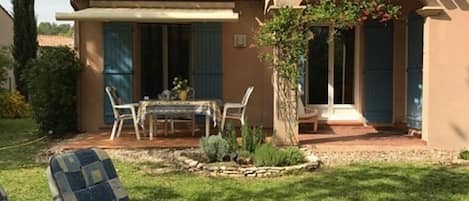 Terrasse vue sur jardin avec chaises longues à l'ombre des chênes